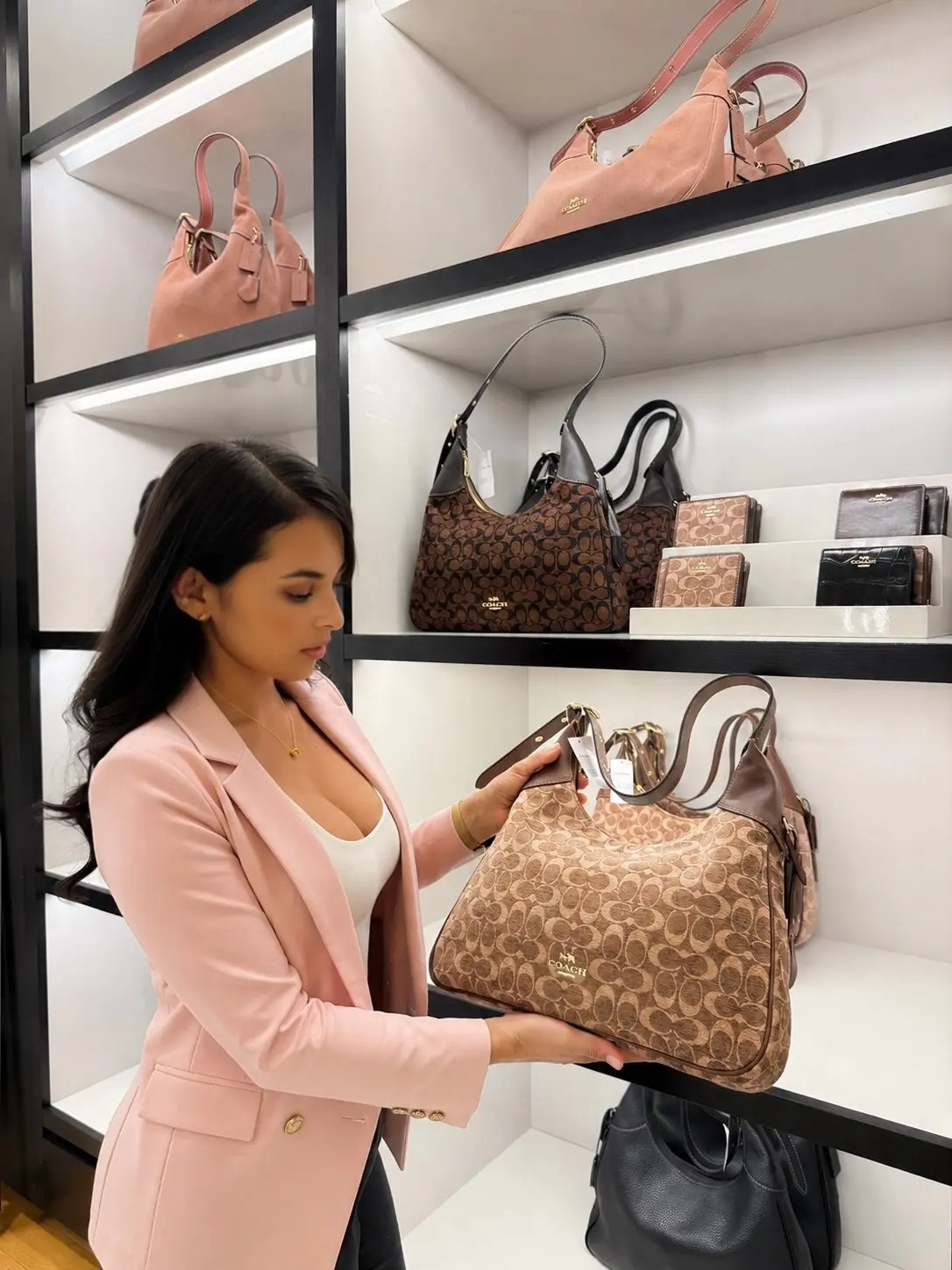 Andrea revisando una cartera Coach en tienda